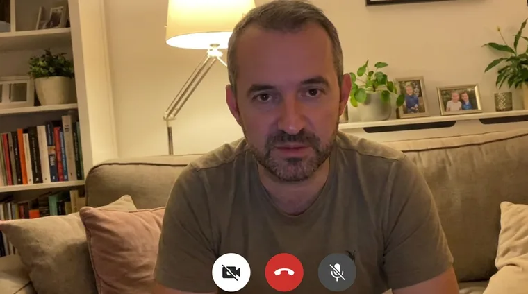 Still uit de telefoonvideo van Dijk: woonkamer, T-shirt, recht in de camera